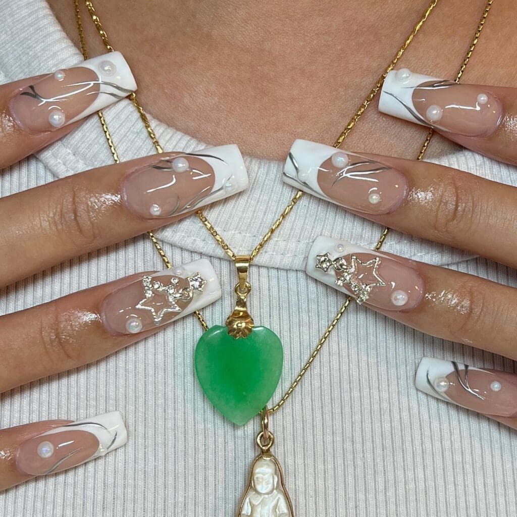 unghie con applicazioni di perle e bijoux