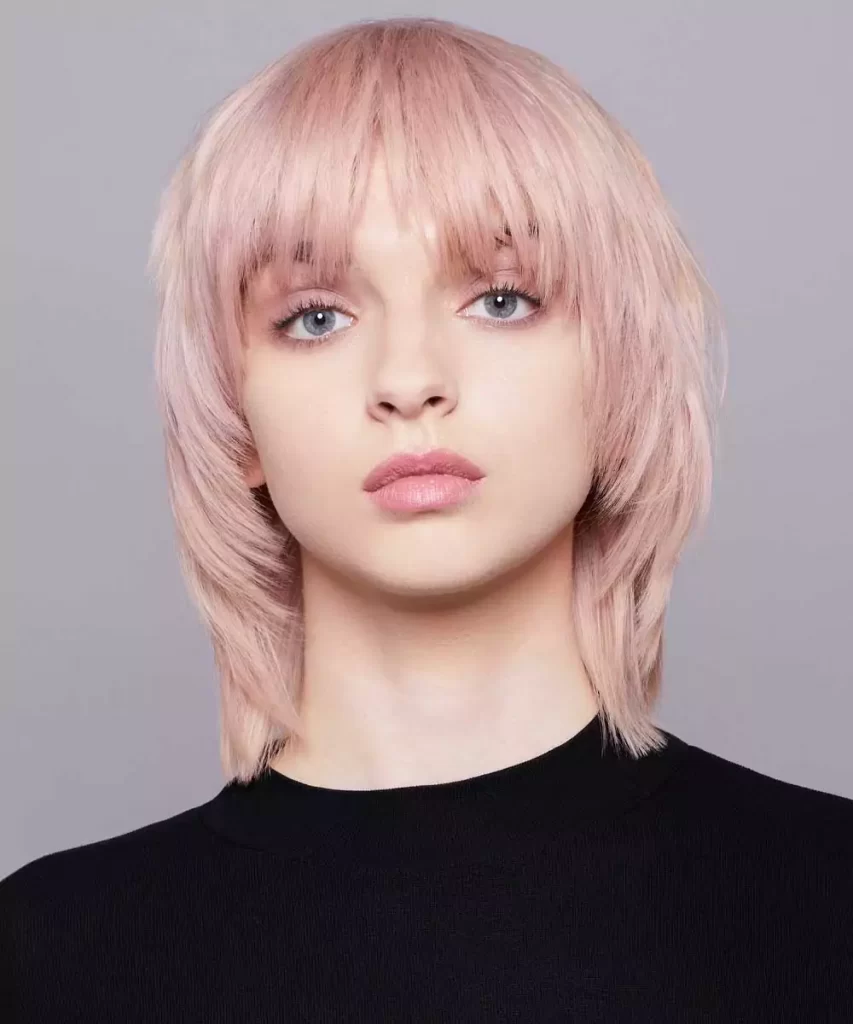 Taglio capelli corti con frangia sfilata, colore biondo rosa